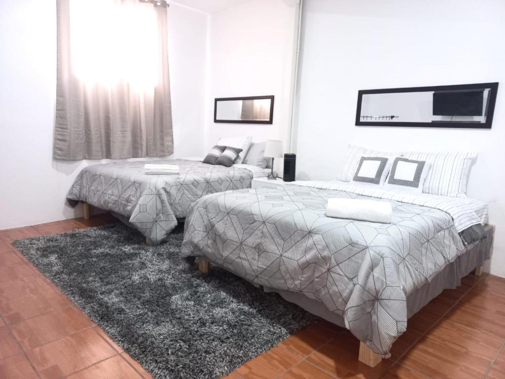 a bedroom with two beds and a tv on the wall at W's Hostel in San José