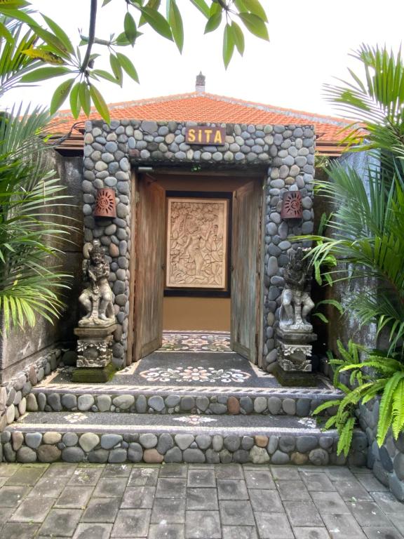 una entrada a una casa con un edificio de piedra en Rama Village, en Canggu