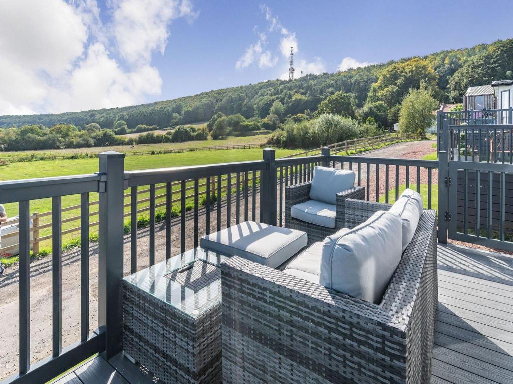 a patio with a couch and chairs on a balcony at Red Wood Lodge - Uk40849 in Scarborough