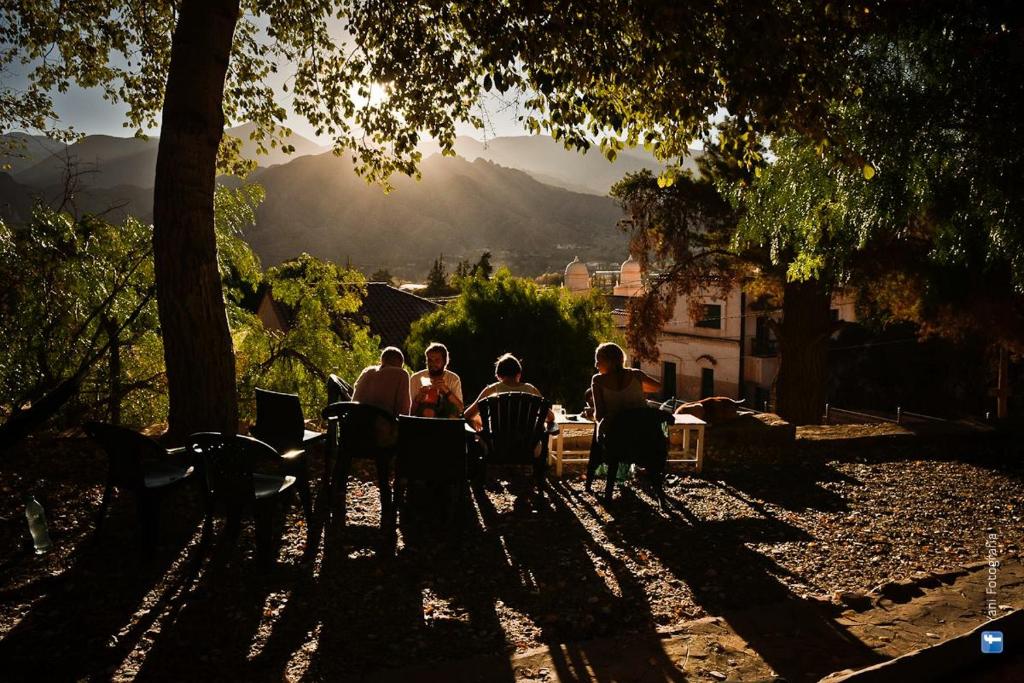 a group of people sitting at a table in a park at Casamolle Hostel in Tilcara