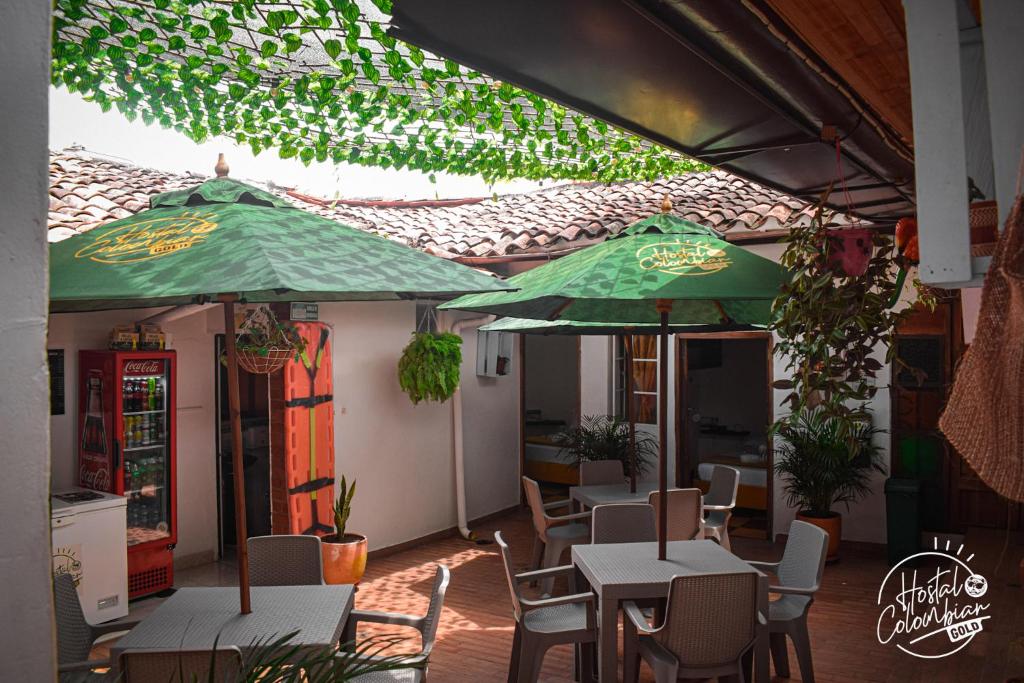 a restaurant with tables and chairs and umbrellas at Hostal Colombian Gold in San Gil