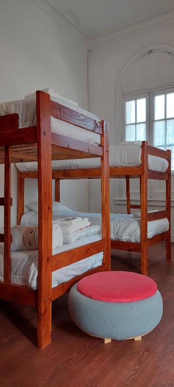 Hostel B&B Tandil في تانديل: غرفة بسريرين بطابقين وسجادة حمراء