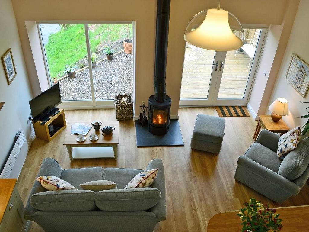 a living room with a couch and a wood stove at Bridge Cottage in New Channelkirk
