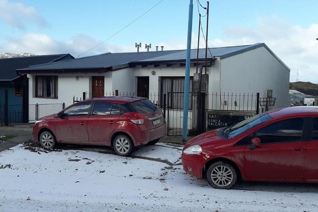 two cars parked in a parking lot in front of a house at Cabaña El Horizonte Patagónico in Ushuaia
