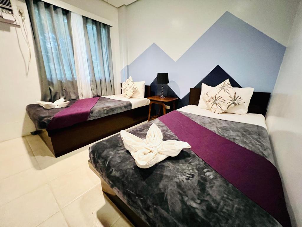 una habitación de hotel con 2 camas con flores. en Coron Ecolodge, en Corón
