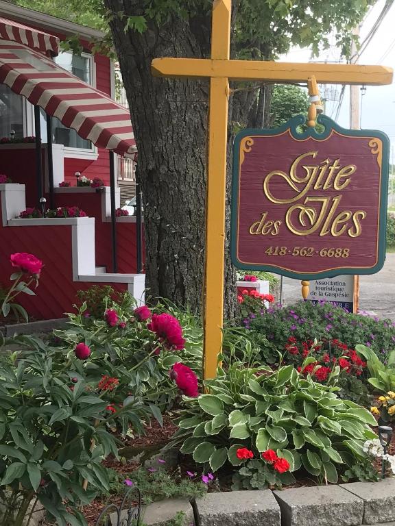 a sign for a site of flowers in a garden at gite des iles in Matane