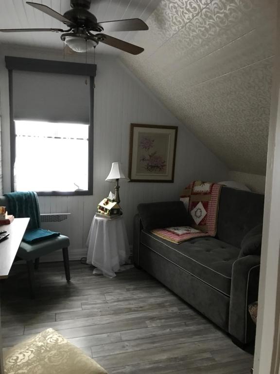 a living room with a couch and a ceiling fan at gite des iles in Matane