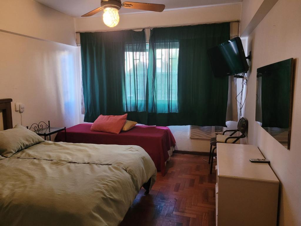 una habitación de hotel con dos camas y un televisor en Edificio Independencia Lavalle 35, en Mendoza