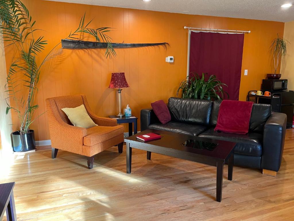 sala de estar con sofá de cuero y silla en Turnagain Guest House, en Anchorage