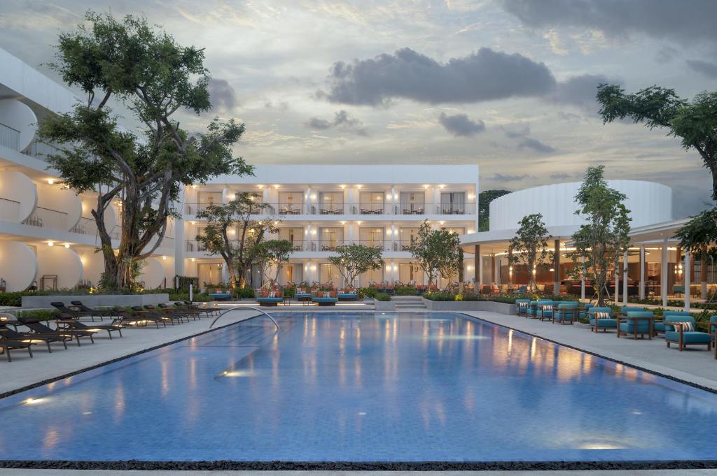 eine Außenfassade eines Hotels mit einem großen Pool in der Unterkunft Avani Chaweng Samui Hotel & Beach Club in Chaweng