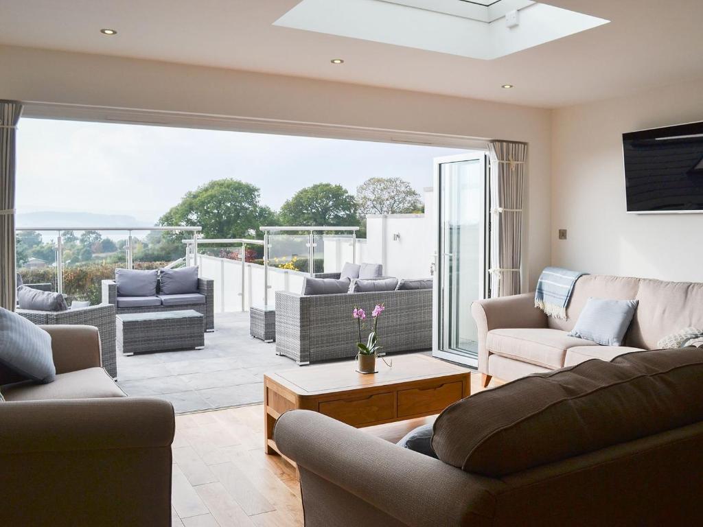 a living room with couches and a large window at Estuary View in Lympstone