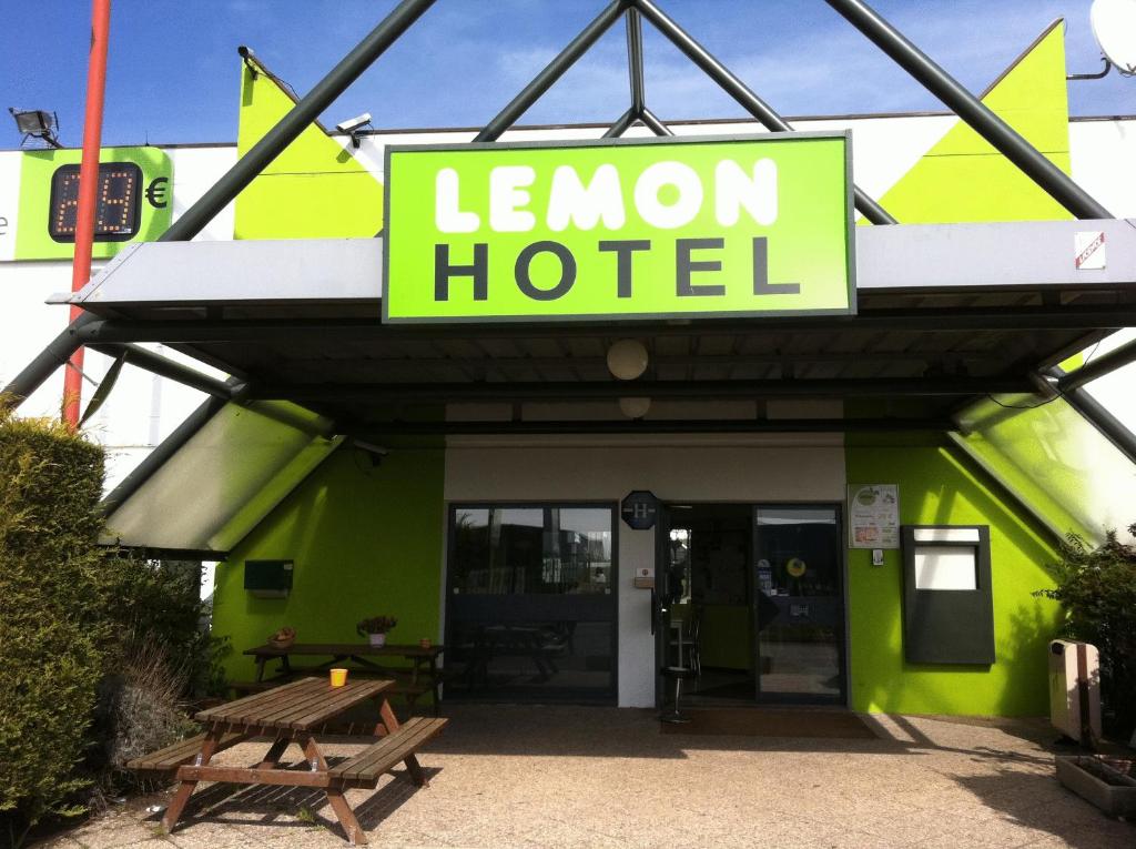 a green building with a sign that reads lemon hotel at Lemon Hotel Dreux Chartres in Dreux