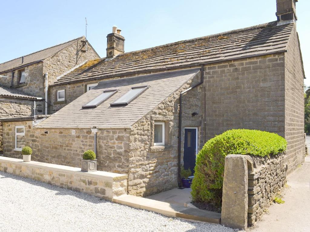 an old stone house with skylights on it at Blackcurrant Cottage At Stanton Ford Farm in Baslow