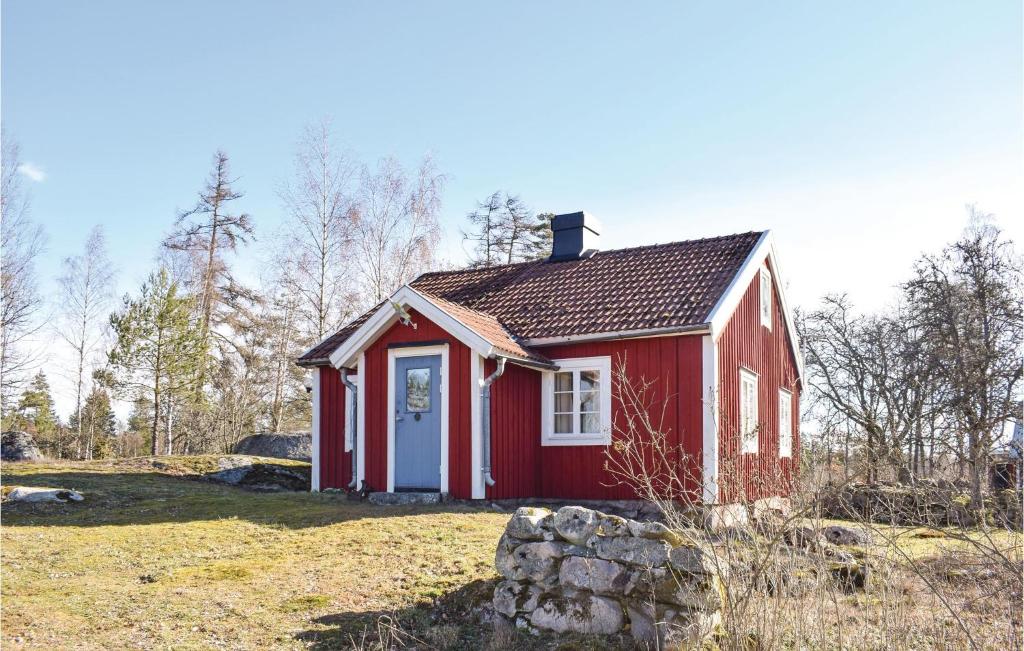 una casa roja con una puerta blanca en un campo en 2 Bedroom Nice Home In Lnashult en Lönashult