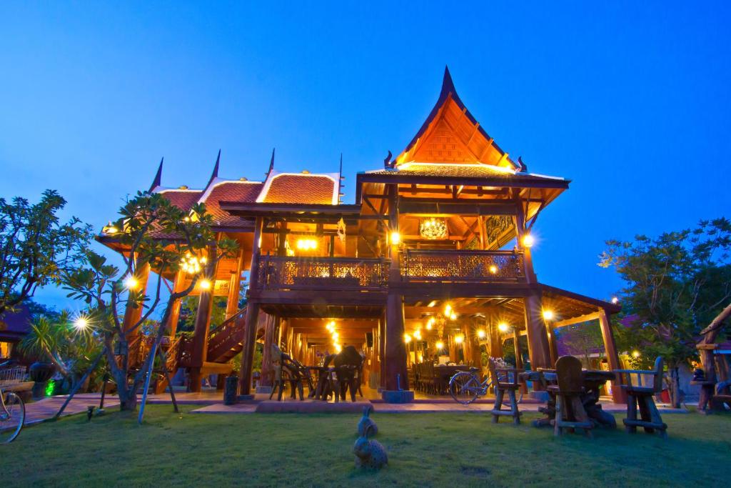 a large tree house with chickens standing around it at Bueng Bua Thong Resort in Ban Huai Yai