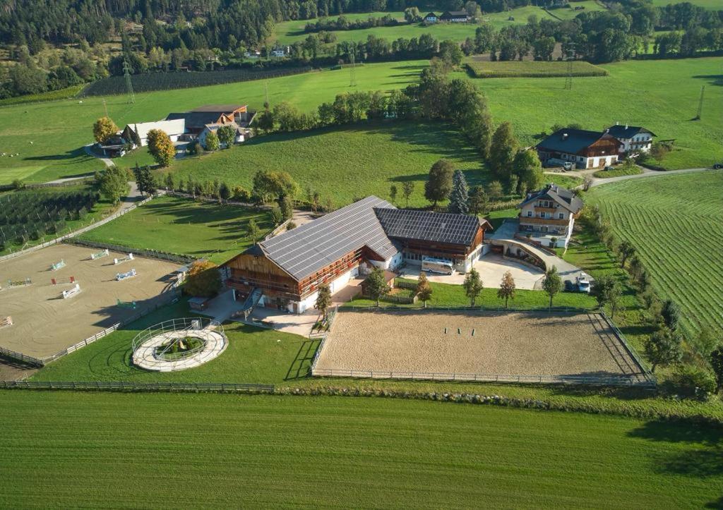 an aerial view of a house in a green field at Schönhuberhof - Panoramalage in Brunico