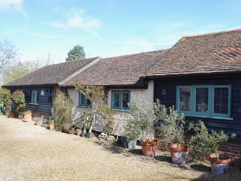 a house with potted plants in front of it at The Stables in Elmstone