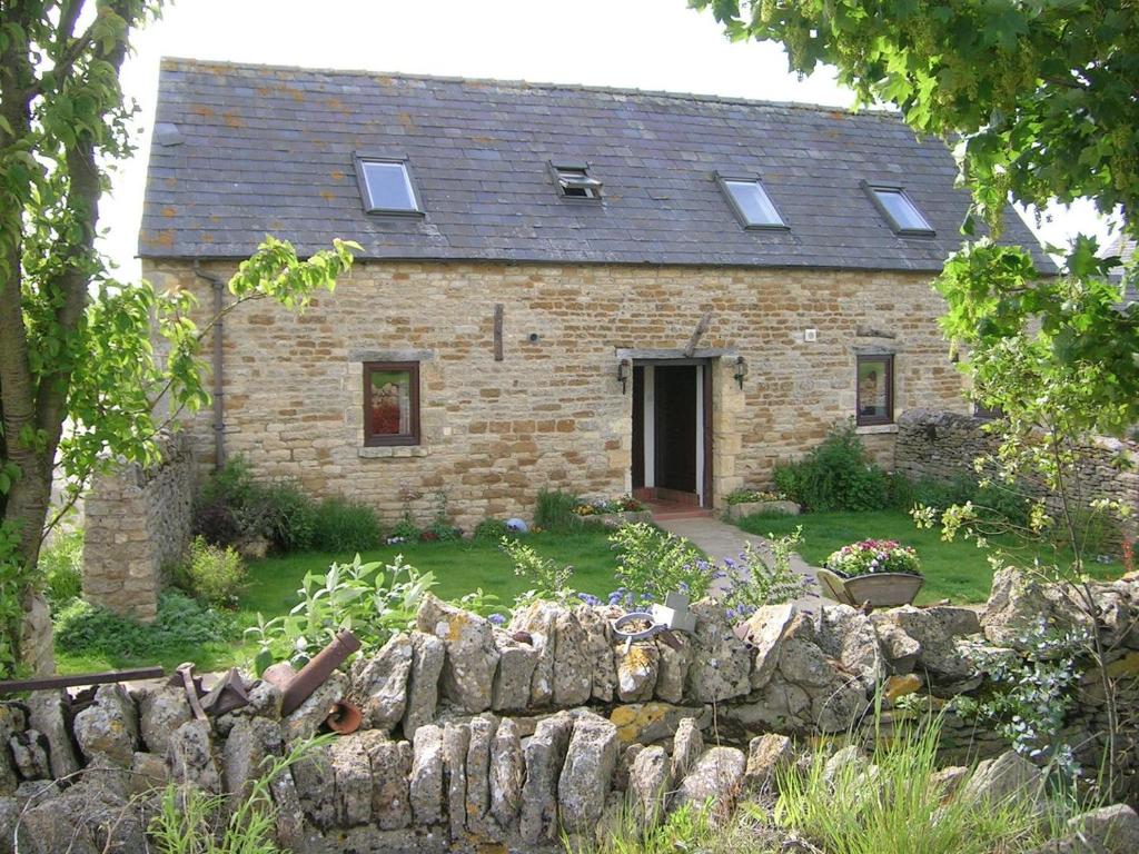 an old stone house with a stone wall at Stable Cottage - Ukc3630 in Adlestrop