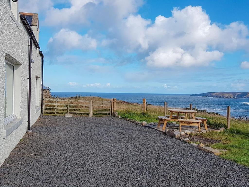 a picnic table next to a building with a view of the ocean at Ethels House in Armadale