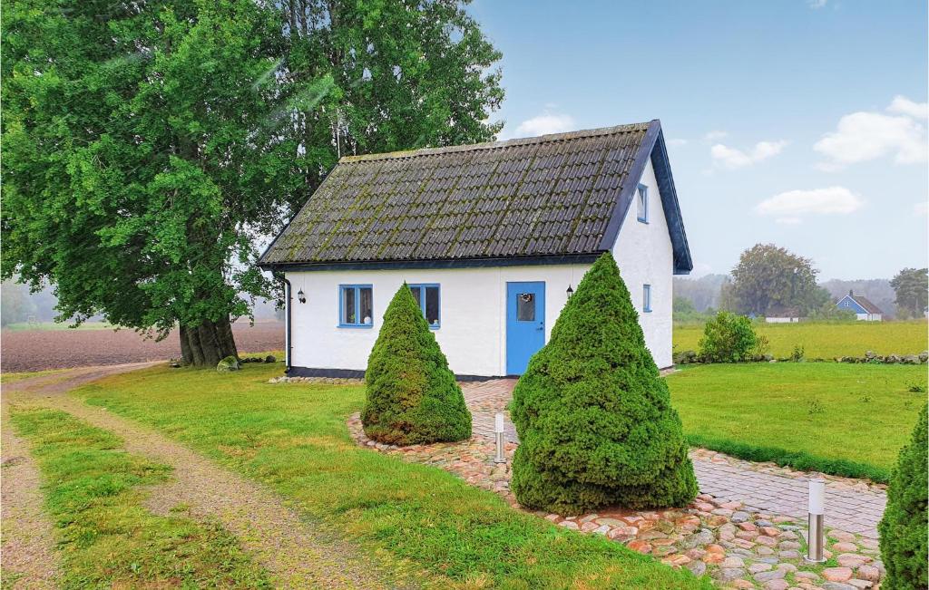 uma pequena casa branca com duas árvores em frente em 2 Bedroom Beautiful Home In Hrby em Hörby