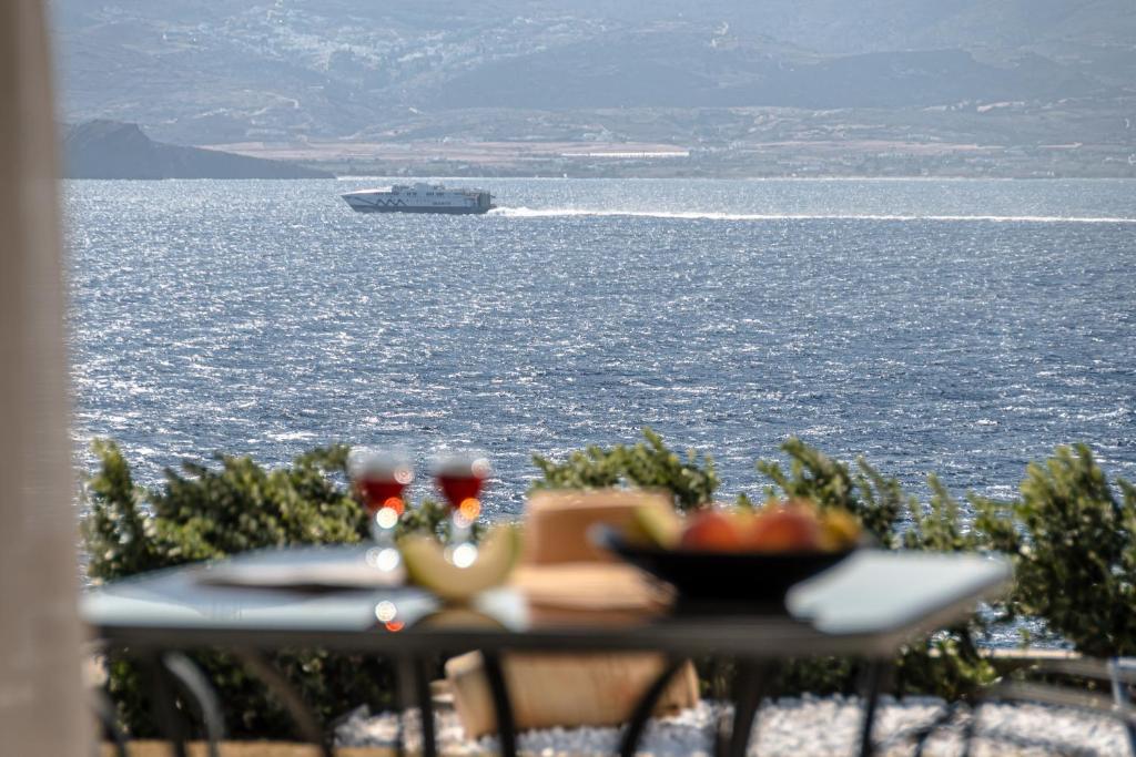 uma mesa com uma tigela de comida e um barco na água em Dionysus House and Ariadne Apartment em Stelida
