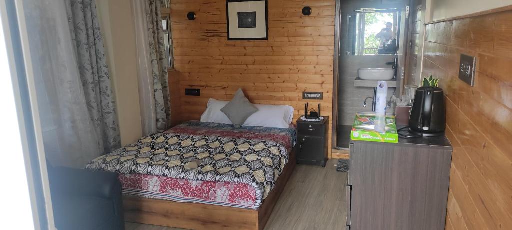 een kleine slaapkamer met een bed in een kamer bij Tito's Homestay in Kalimpong