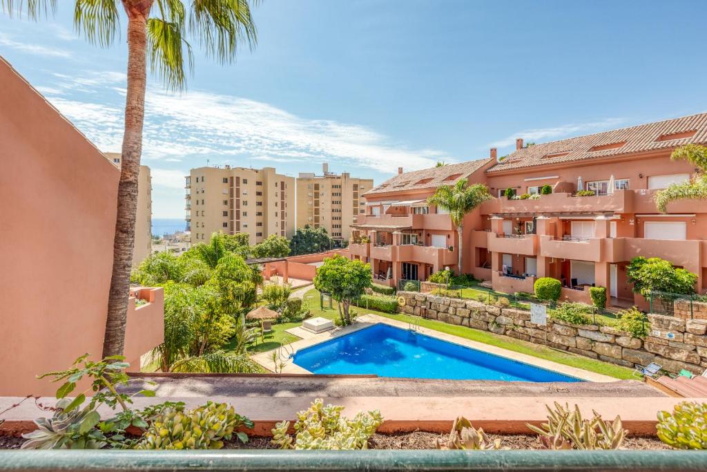 een appartement met een zwembad en palmbomen bij La Fragata Penthouse LF1 in Estepona