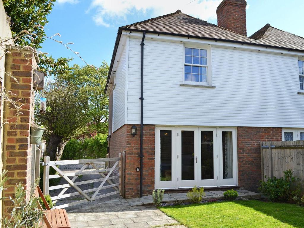 una casa con puertas blancas y una valla en Durdrich Cottage en St Margarets at Cliff