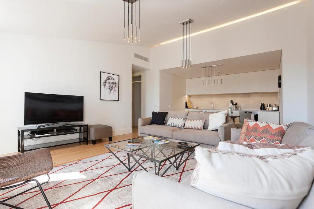 ein Wohnzimmer mit einem Sofa und einem Flachbild-TV in der Unterkunft FLH Mouraria Art Apartment with Pool in Lissabon