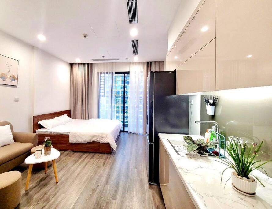 a room with a bed and a couch and a kitchen at Titmit Studio-Căn hộ cao cấp VinhomesOceanPark in Hanoi