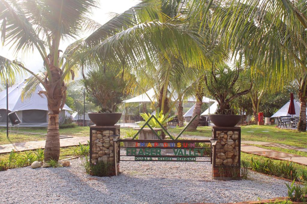 ein Schild vor einem Park mit Palmen in der Unterkunft Inap Dusun Fraser Valley Kuala Kubu Bharu in Kuala Kubu Baharu