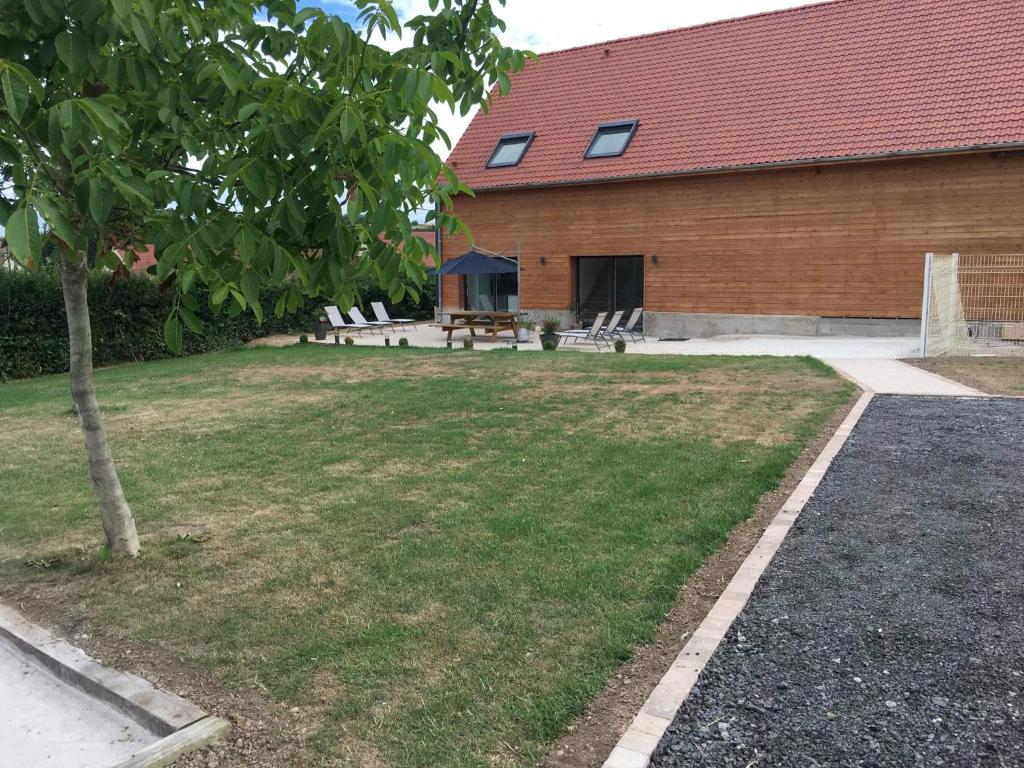 un patio con una mesa de picnic y un edificio en Charmant gîte à la ferme situé à 20 min de la mer en Hermelinghen