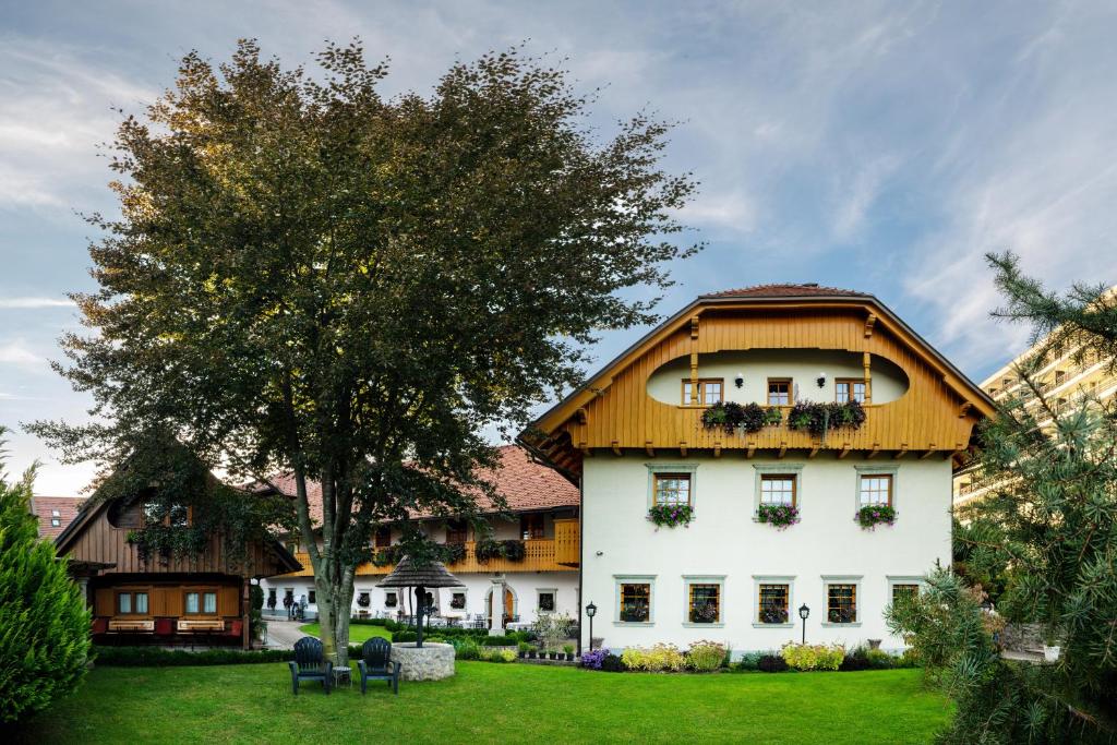 a large white house with a wooden roof at Penzion Mayer in Bled