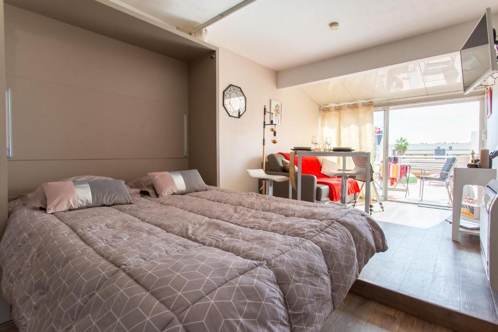 sypialnia z dużym łóżkiem i balkonem w obiekcie Cocooning w Cap d'Agde