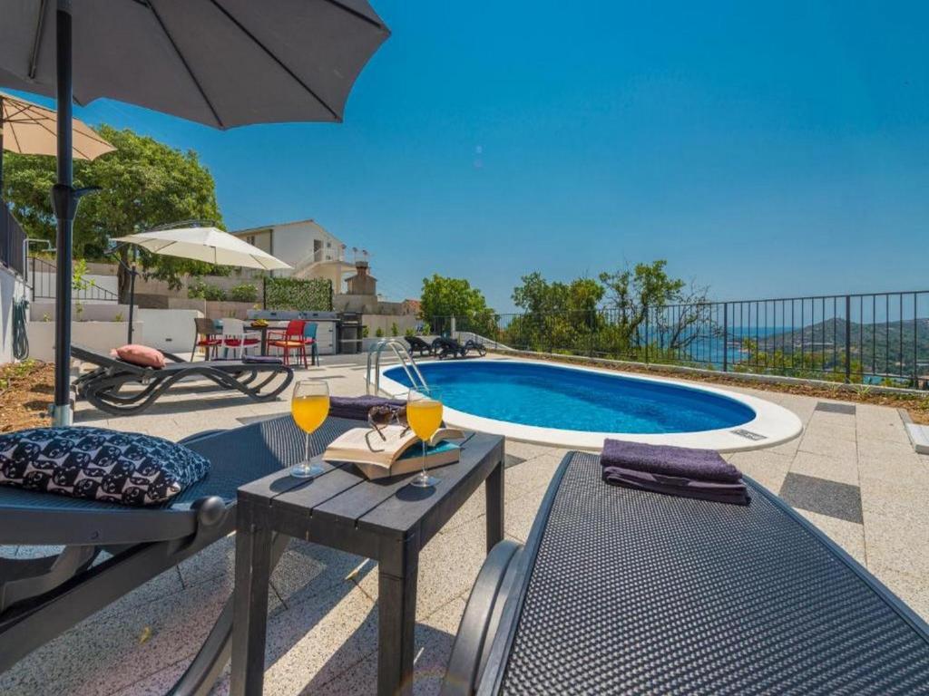 una piscina con una mesa y dos copas de vino en Holiday Home Nest, en Mlini