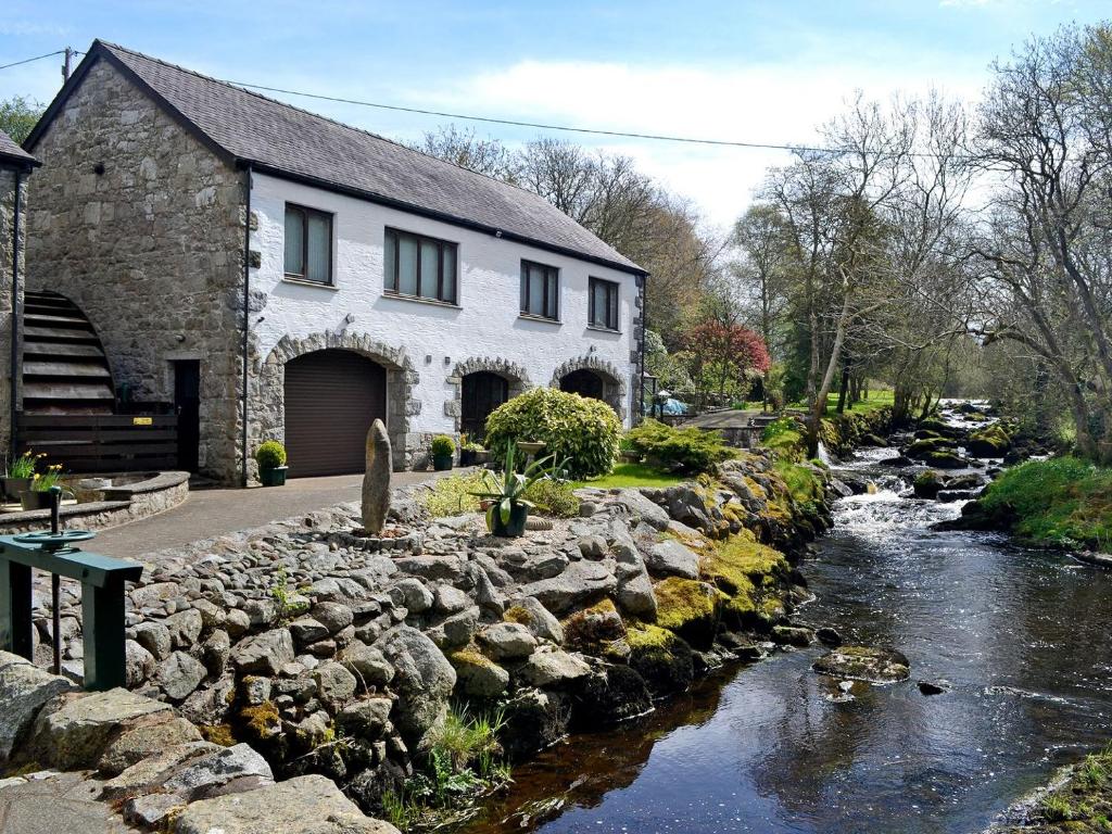 a house with a river in front of a building at Anvil in Dalbeattie