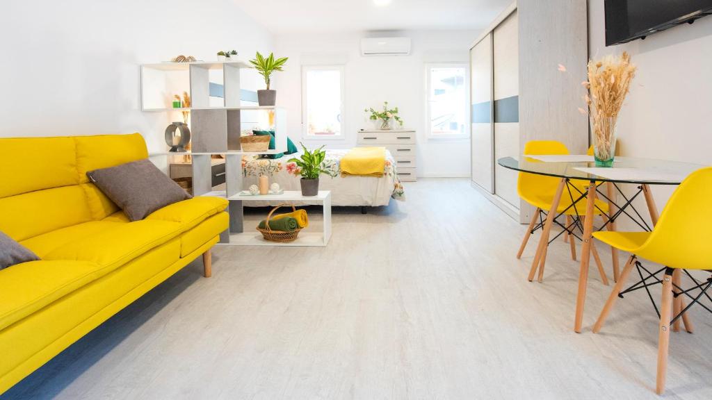 - un salon avec un canapé jaune et une table dans l'établissement Acogedora casa de invitados con piscina compartida, à Tolède