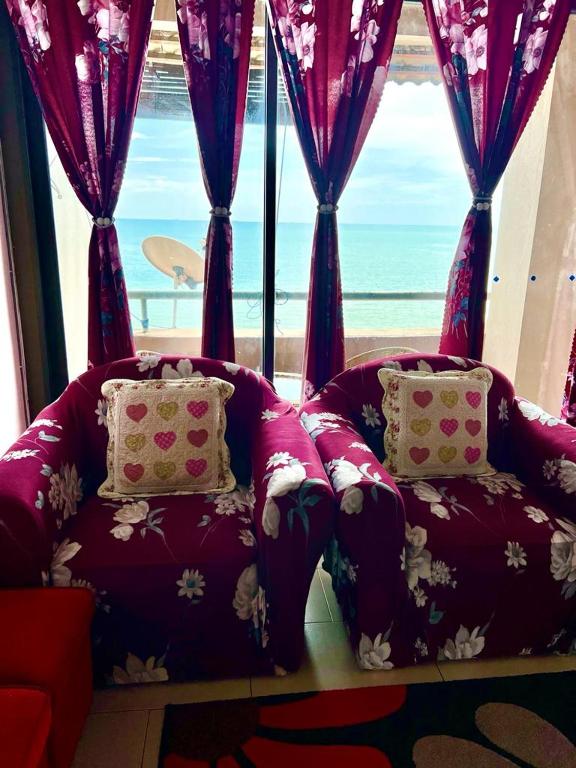 uma sala de estar com um sofá e uma grande janela em PD VIP SEAVIEW w Wifi n Smart TV em Port Dickson
