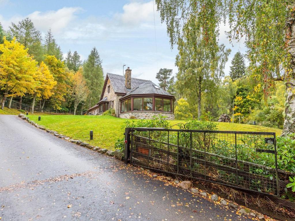 a house with a gate in front of a house at The Old Boathouse in Cromdale