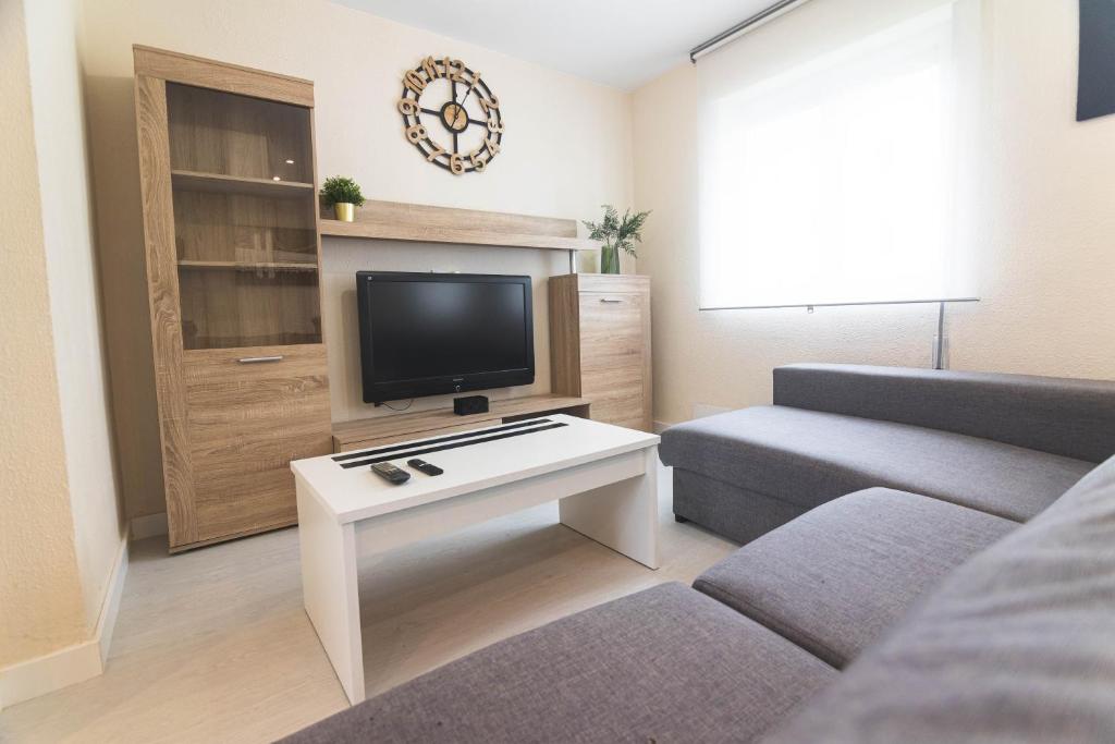 a living room with a tv and a couch at Apartamento chile playa in Gijón