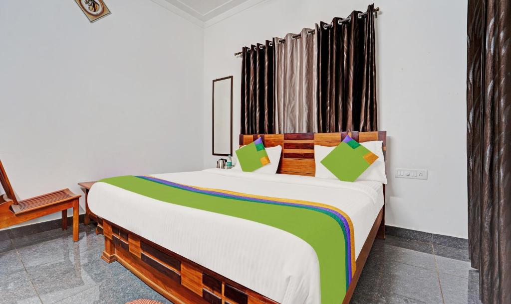 a bedroom with a large bed in a room at Treebo Trend Alaka Rester Homestay in Madikeri