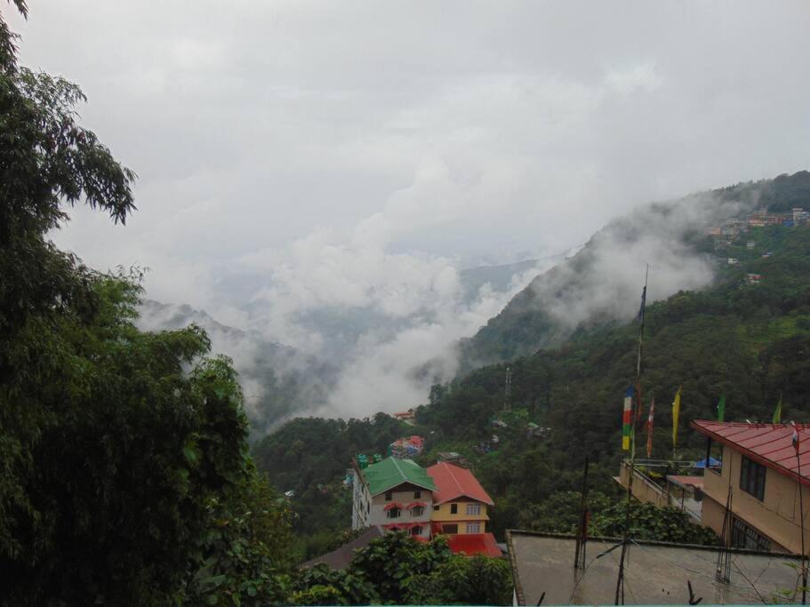 a view of a mountain with clouds in the distance at BOJO house in Gangtok