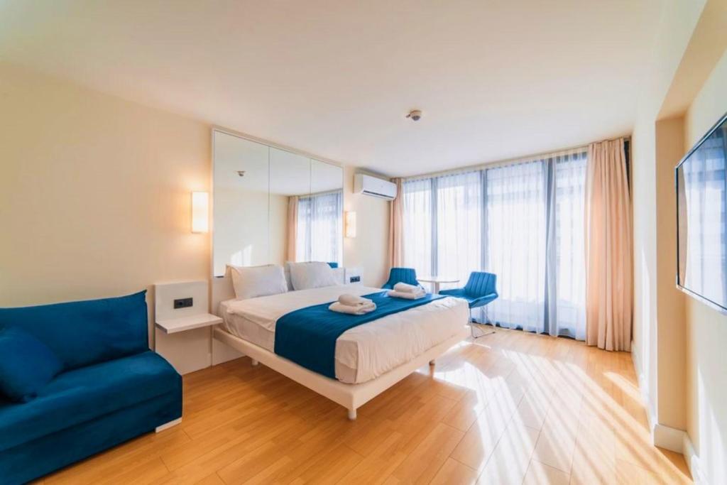 una camera con un letto e un divano blu di Superior Apartments Orbi City Sea View a Batumi