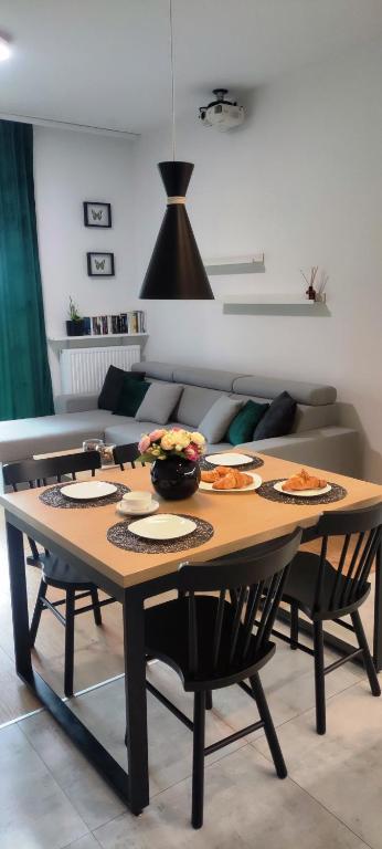 una mesa con platos de comida en la sala de estar en Nowoczesny apartament z widokiem na park, en Rzeszów