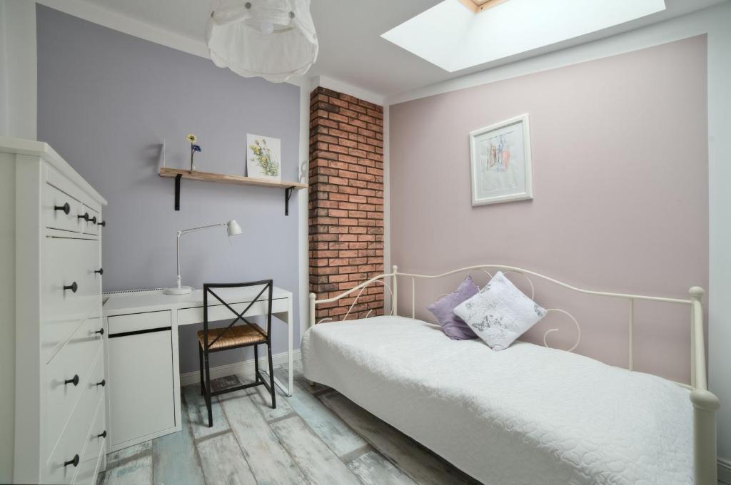 a bedroom with a bed and a desk in it at Urban Nest Apartments Bon 5 in Krakow