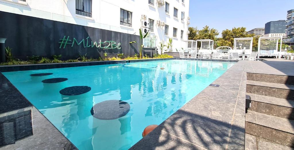 Johannesburg的住宿－MINT Hotel 84 on Katherine，大楼前的游泳池