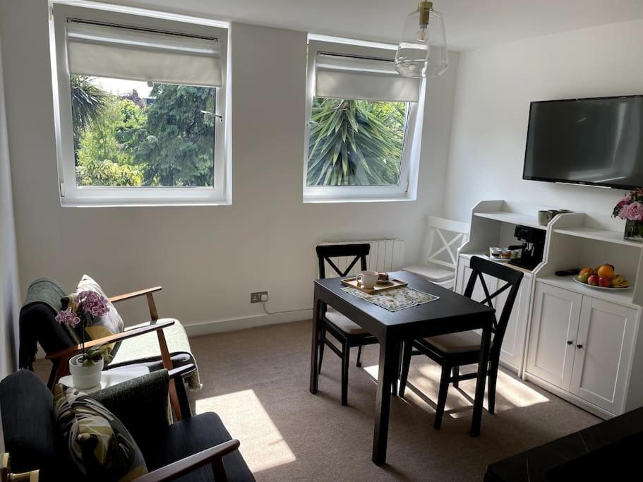 ロンドンにあるBright & modern 1-bed flat in the heart of Fulhamのリビングルーム(テーブル、椅子、窓2つ付)