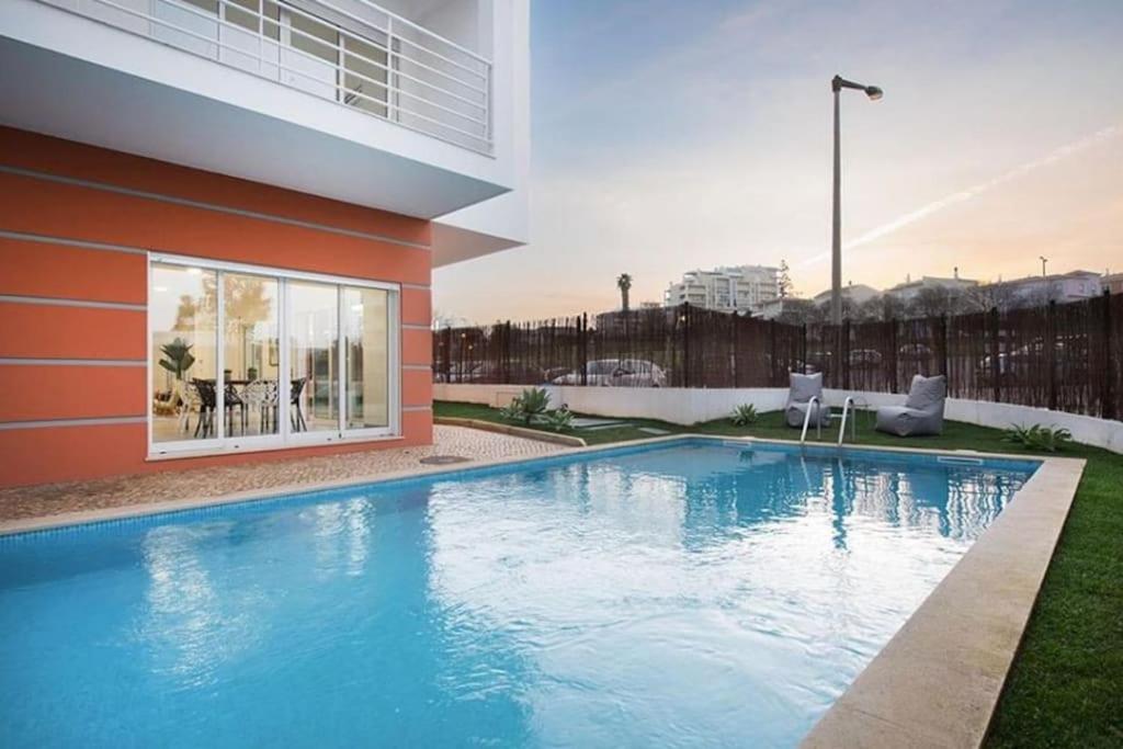 a swimming pool in front of a building at Rochato Dreams in Portimão
