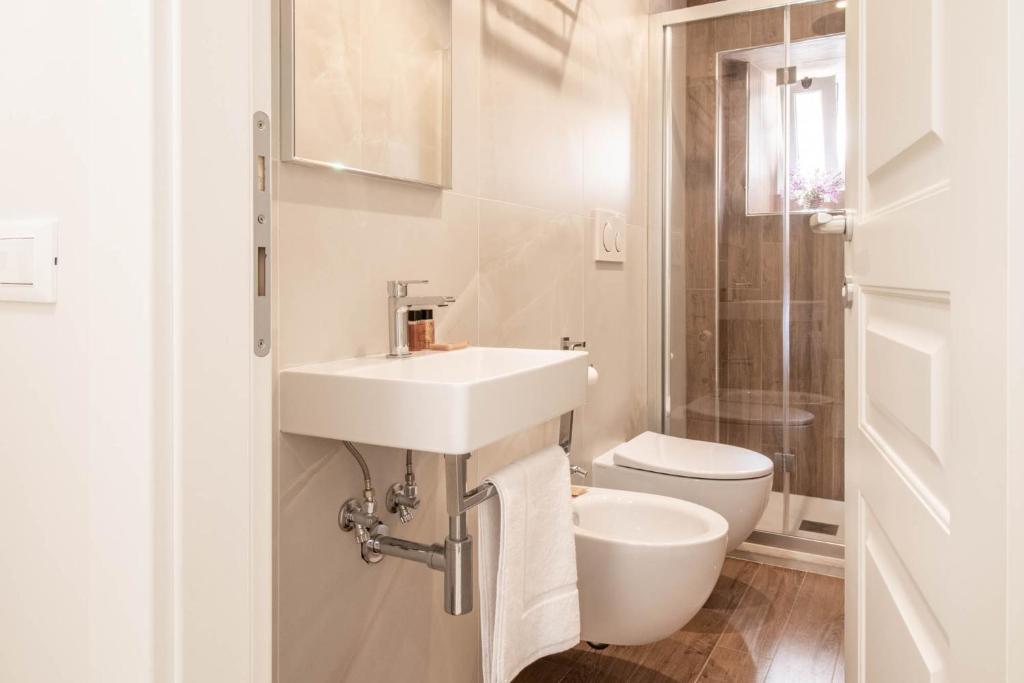 a white bathroom with a sink and a toilet at DANY GUEST HOUSE in Rome