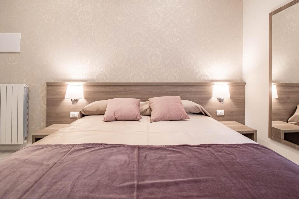 a bedroom with a large bed with two pink pillows at DANY GUEST HOUSE in Rome
